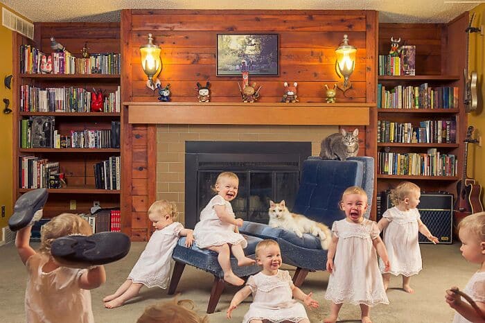 Babies in white dresses posing humorously in a cozy living room, perfect for a funny Christmas card.