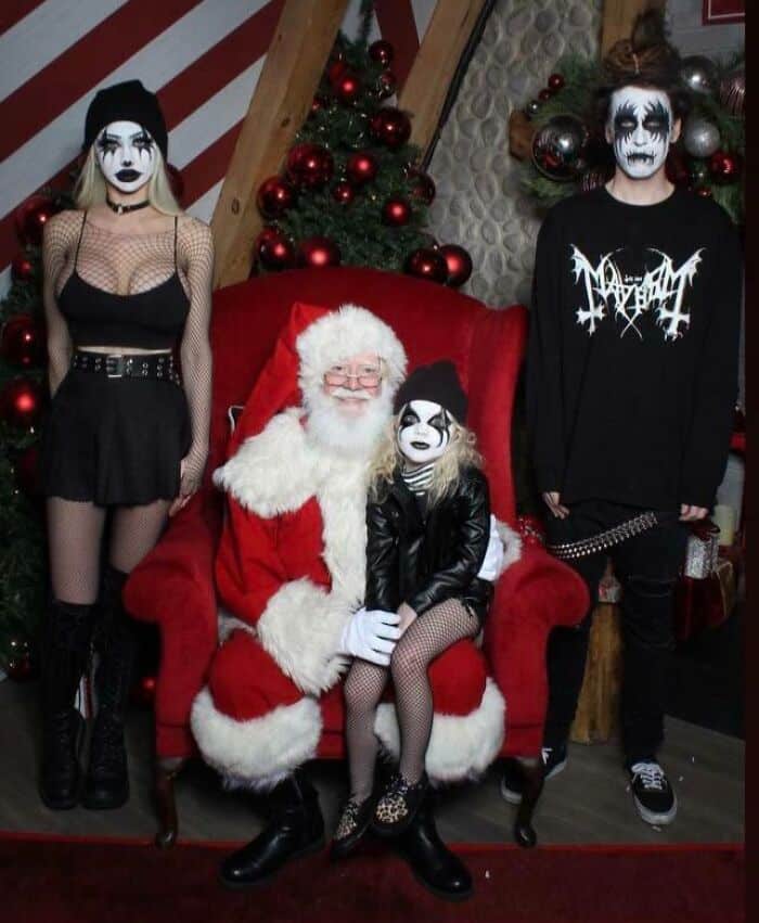 Funny Christmas card with Santa and people in gothic costumes posing humorously.