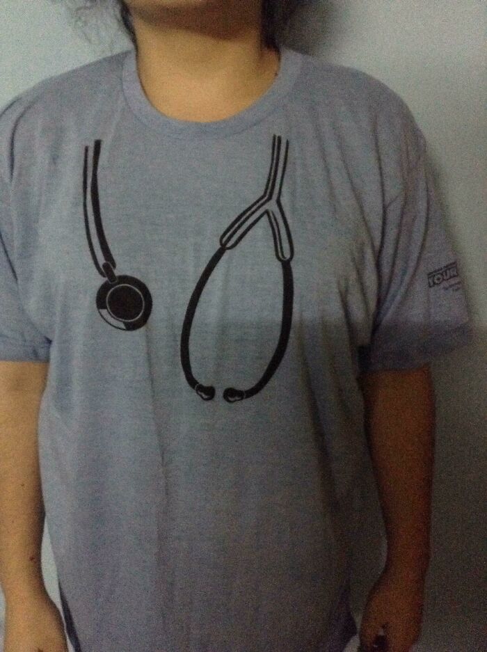 Person wearing a gray t-shirt with a printed stethoscope design, illustrating careless online shopping backfired humor.